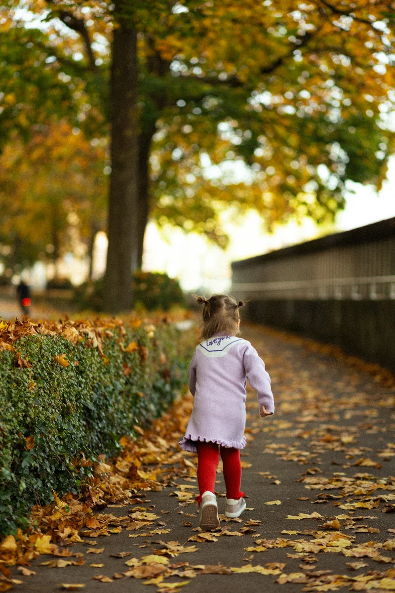 Kinderfotografie Outdoor – Kleinkind spaziert allein auf herbstlichem Weg