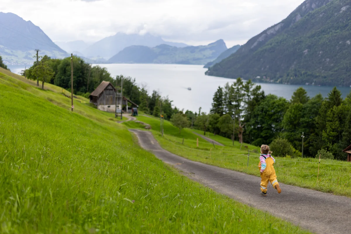 Baby Fotografie Schweiz – Kleinkind läuft am Vierwaldstättersee mit Bergpanorama