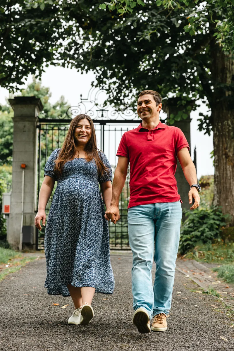 Schwangerschaftsfotos Kastanienbaum – Paar spaziert Hand in Hand durch den Park
