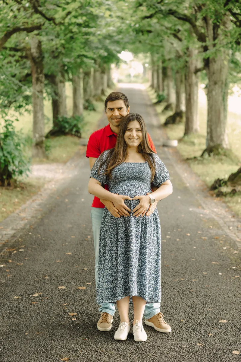 Babybauch Shooting Schweiz – Paar formt ein Herz mit den Händen auf dem Babybauch