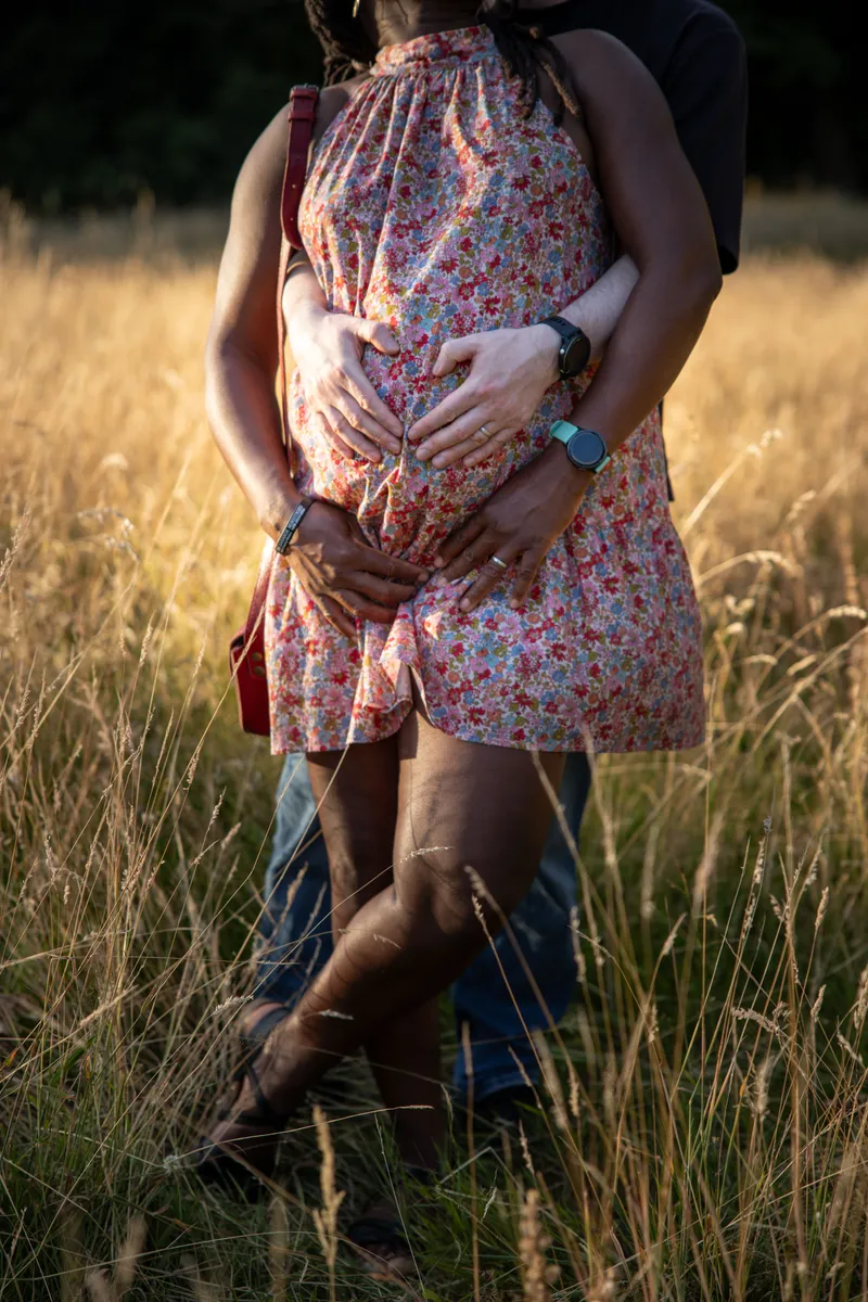 Babybauch Fotoshooting Dreilindenpark – Paar küsst sich vor historischer Backsteinfassade