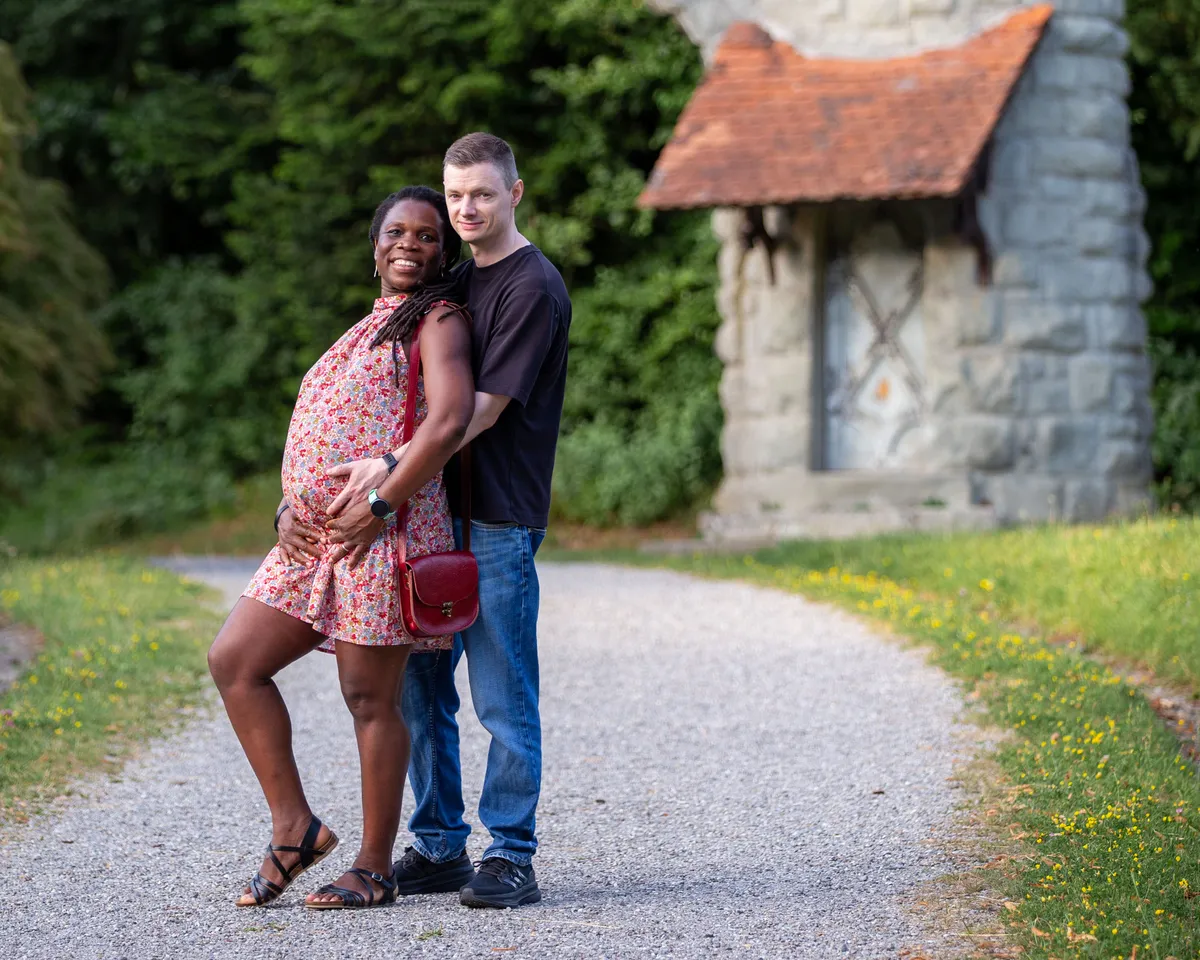Babybauch Fotoshooting Dreilindenpark – Paar tanzt ausgelassen im Blumengarten