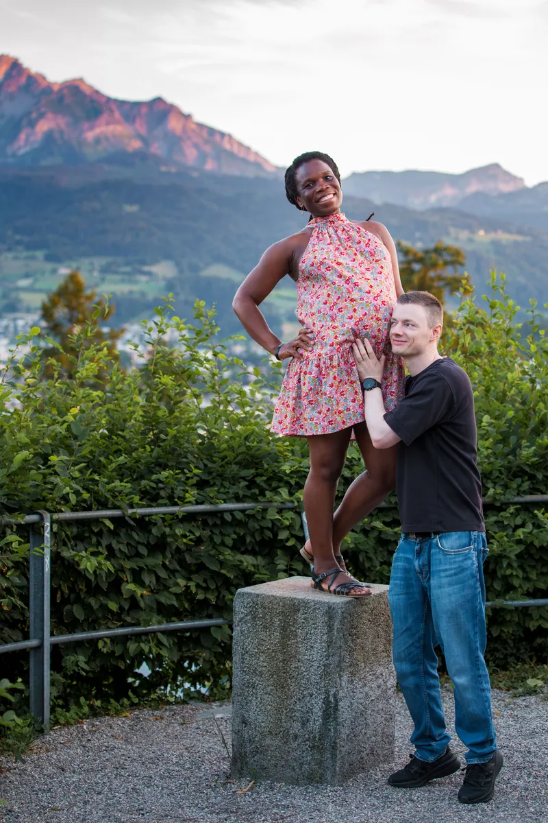 Babybauch Fotoshooting Dreilindenpark Luzern – Paar posiert bei Sonnenuntergang mit Bergpanorama