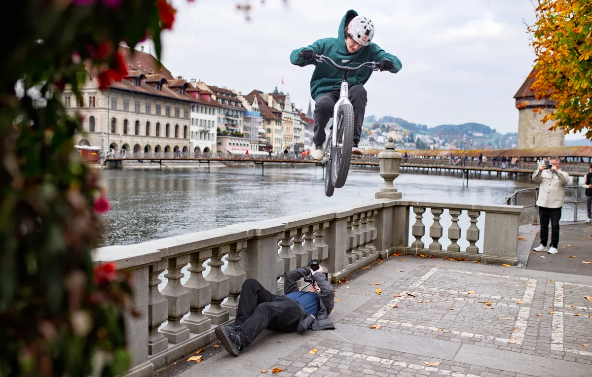 Bike Trials Luzern – Rider springt über liegenden Fotografen an der Kapellbrücke