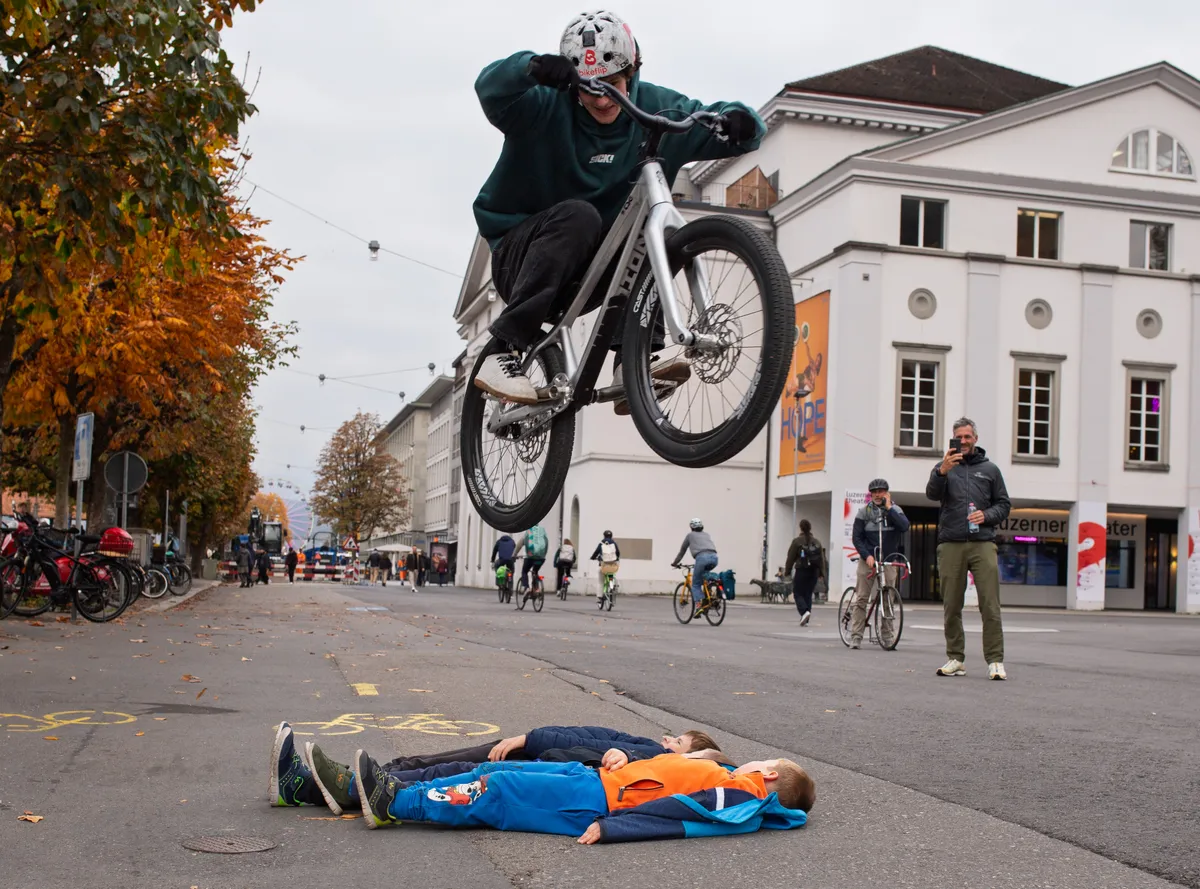Bike Trials Luzern – Rider springt über liegende Kinder auf der Strasse
