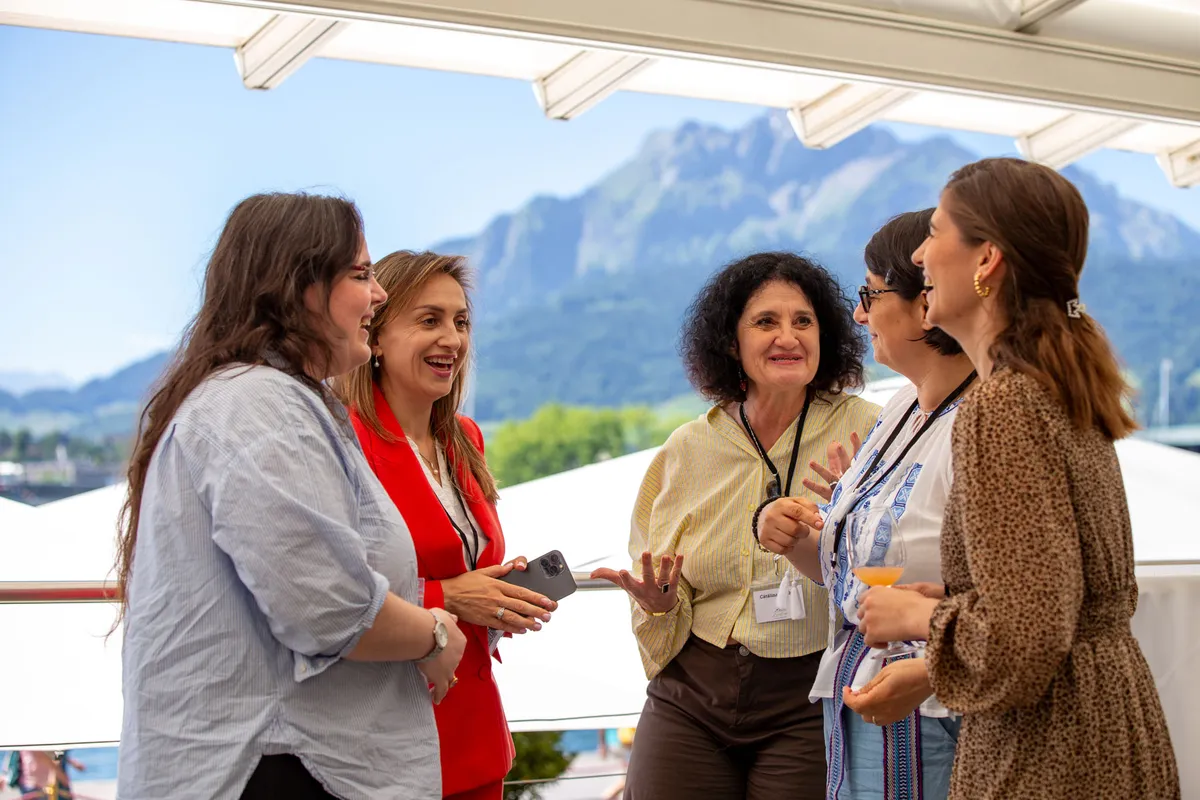 Firmenevent Luzern – Gruppe von Teilnehmerinnen beim Networking auf der Casino-Terrasse mit Alpen und Vierwaldstättersee
