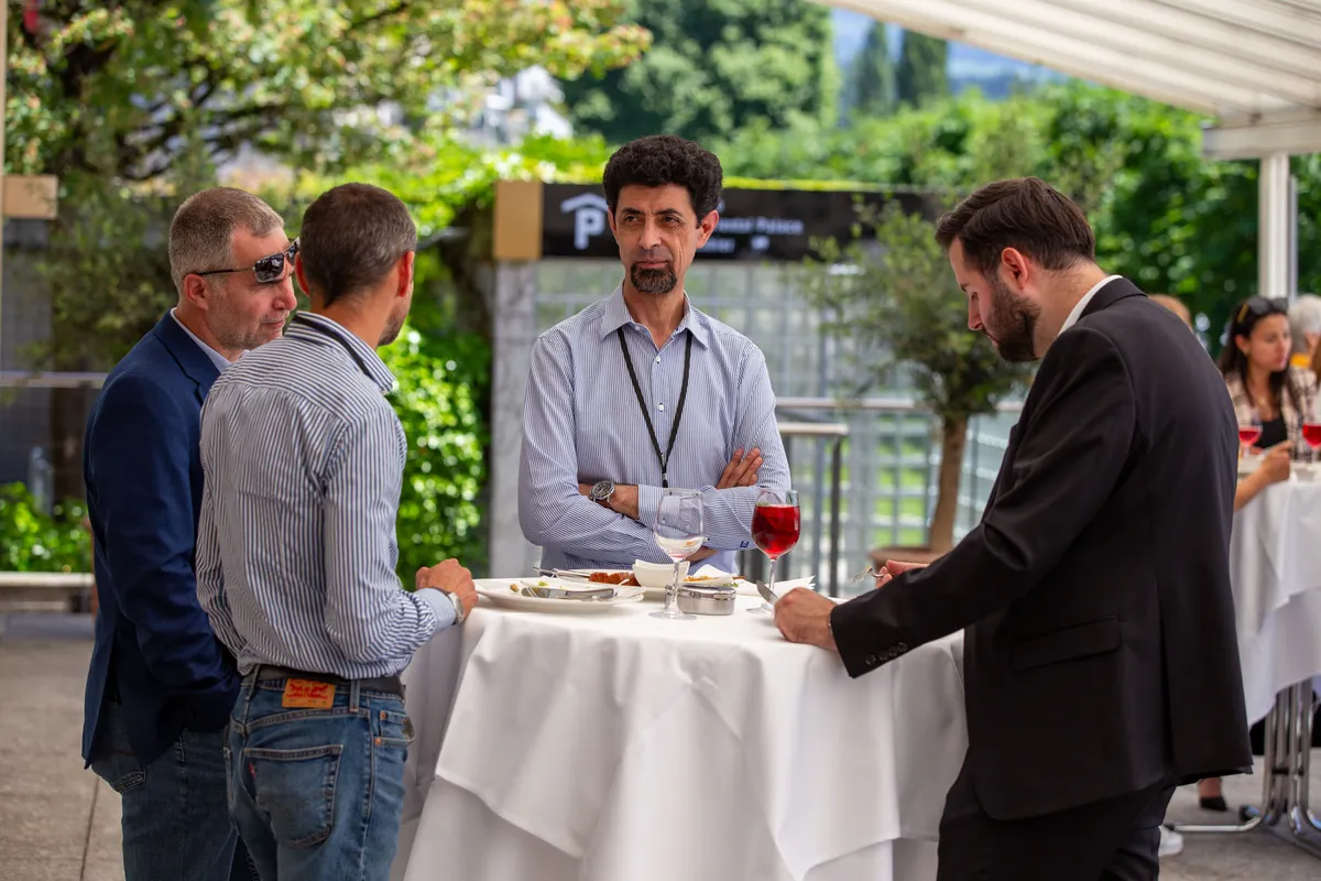 Networking beim Businessevent Grand Casino Luzern – vier Männer im Gespräch an einem Stehtisch im Aussenbereich