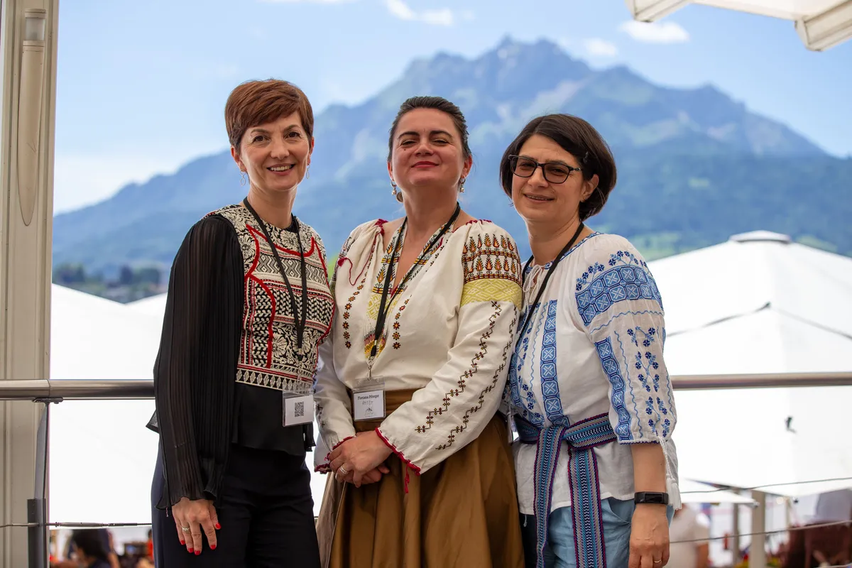 Eventfotografie Luzern – drei Frauen in rumänischer Tracht auf der Casino-Terrasse mit Pilatus im Hintergrund